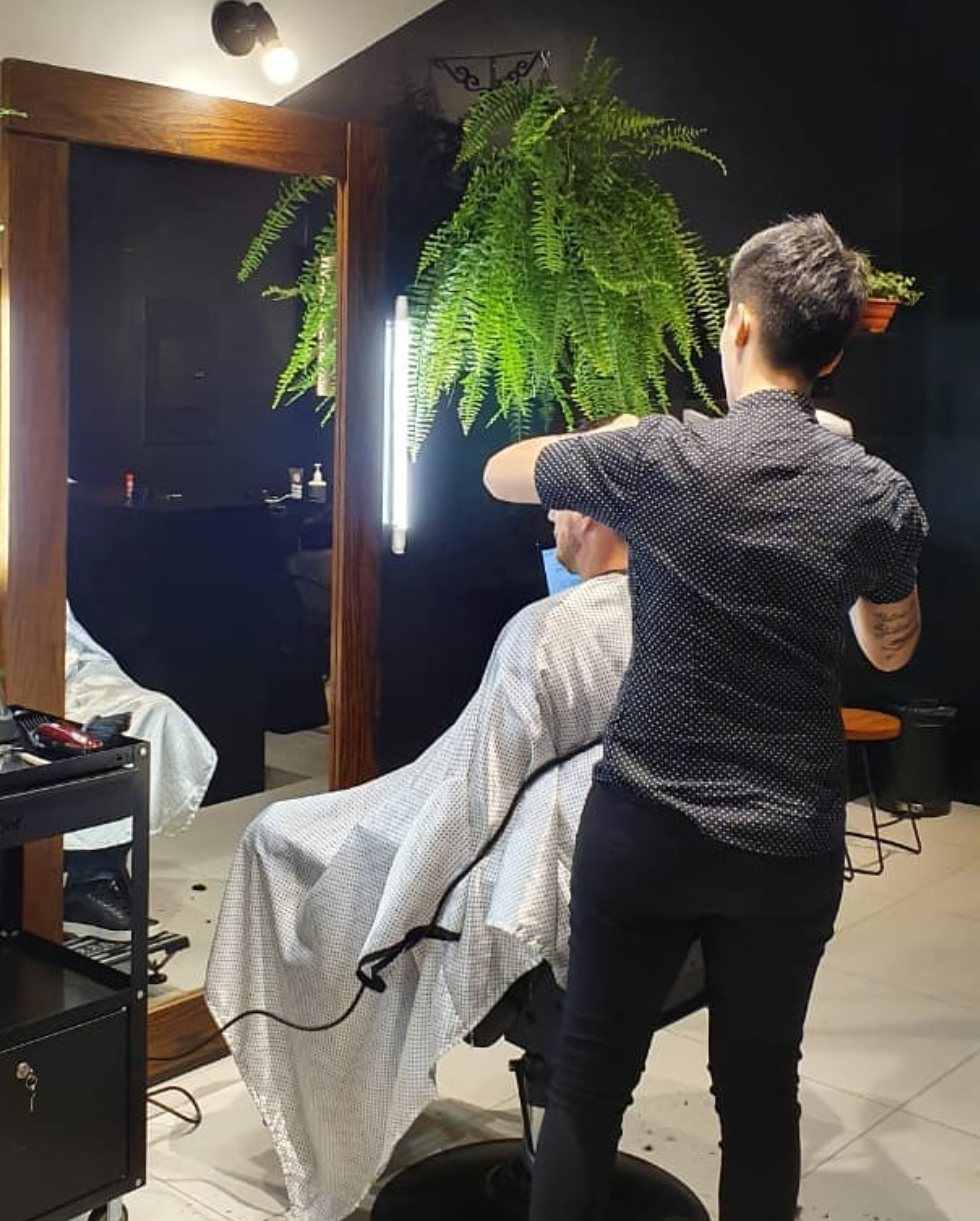 Barbeira atendendo cliente na cadeira